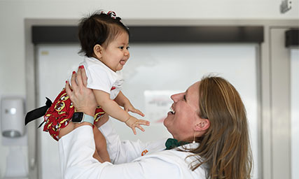 Dr. Frtize holding pediatric patient Ariella Gomez