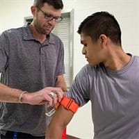 A tourniquet being applied in a Stop the Bleed training