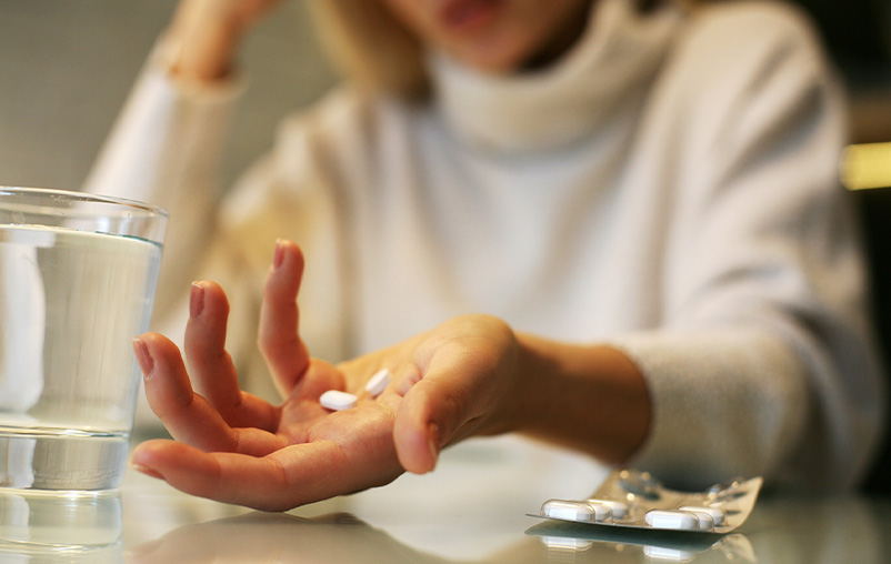 A woman holds pills in her hand