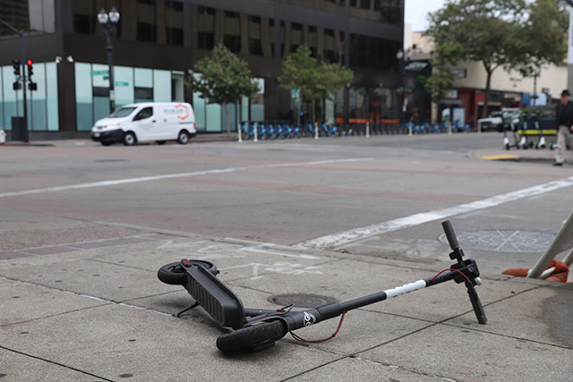 Fallen electric scooter on the sidewalk