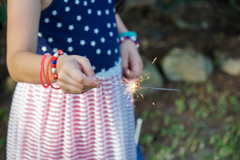 Girl holds sparkler in her hand