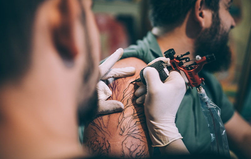 A man gets a tattoo on his shoulder.