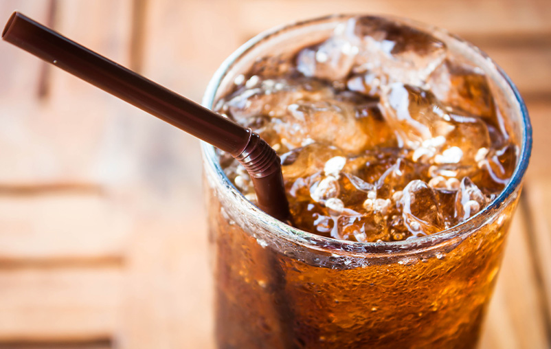 A big glass of diet soda with a straw.