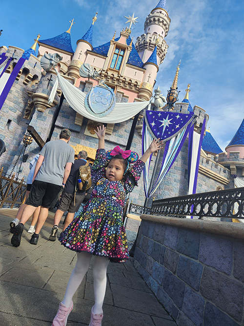 6-year-old Bella stands in front of the castle at Disneyworld