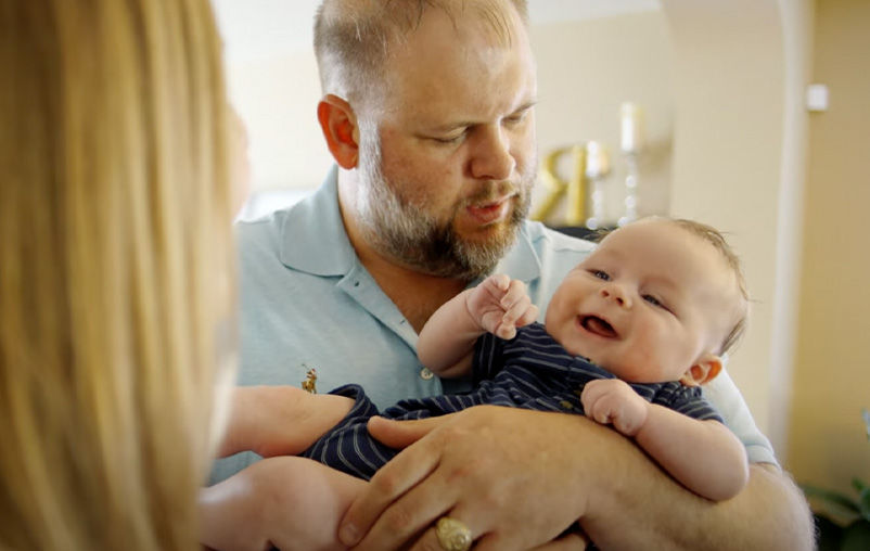Michael Rice holds baby Nathan while Allison Rice looks on.