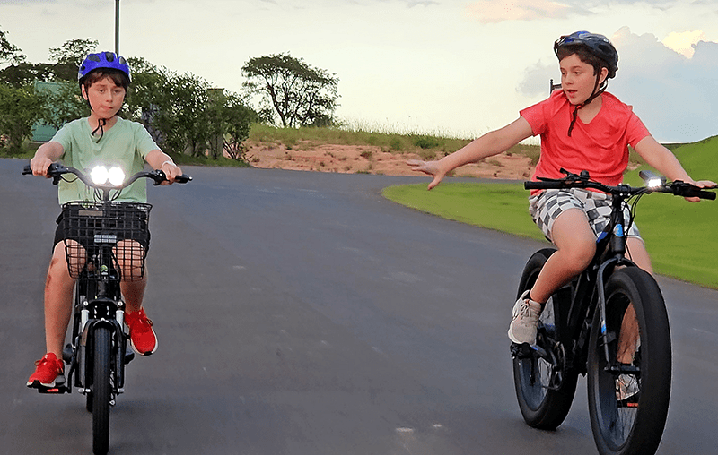 Children riding an electric bike on the road.  