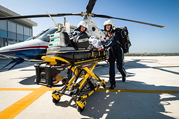 First responders transport a pediatric patient using a helicopter.