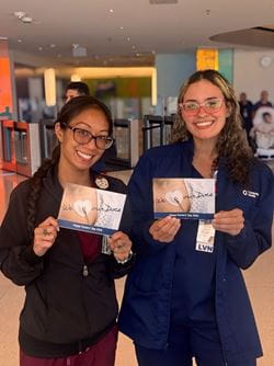 Two University Health team members holding Doctor's Day thank you cards