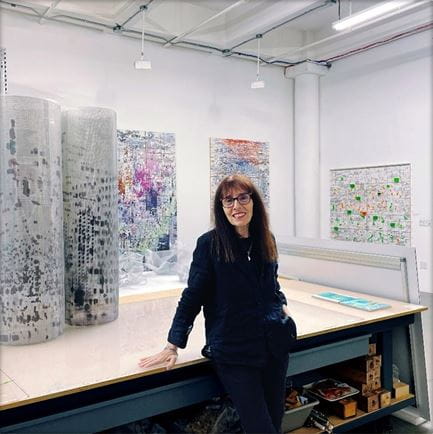 Shuli Sadé standing in front of her art