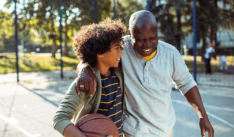 Man walking with boy on basketball court
