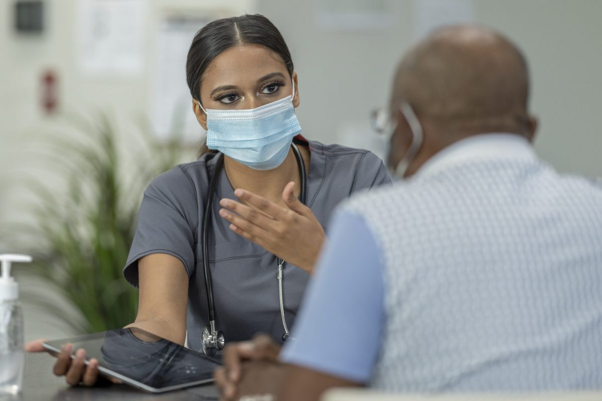 Masked doctor with a patient for a medical appointment