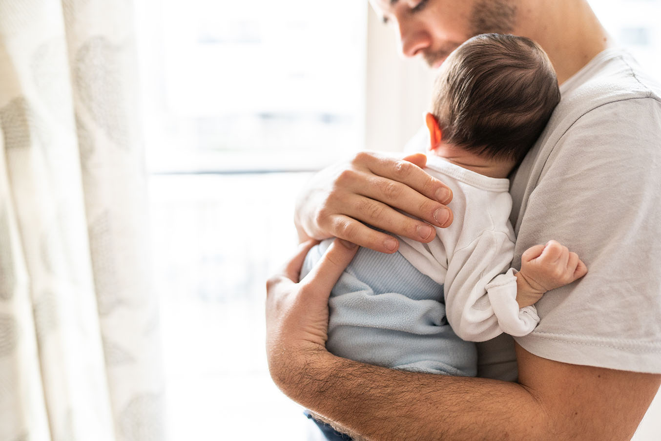 Man holds a newborn baby