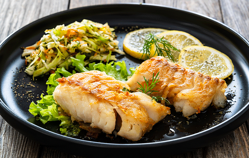 A fish fillet and cabbage slaw on a plate.