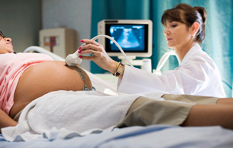 University Health OB provider performing sonogram on pregnant patient 