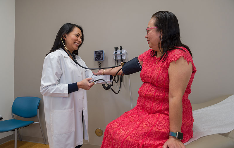 University Health primary care provider at Dominion Crossing checking patients blood pressure. 