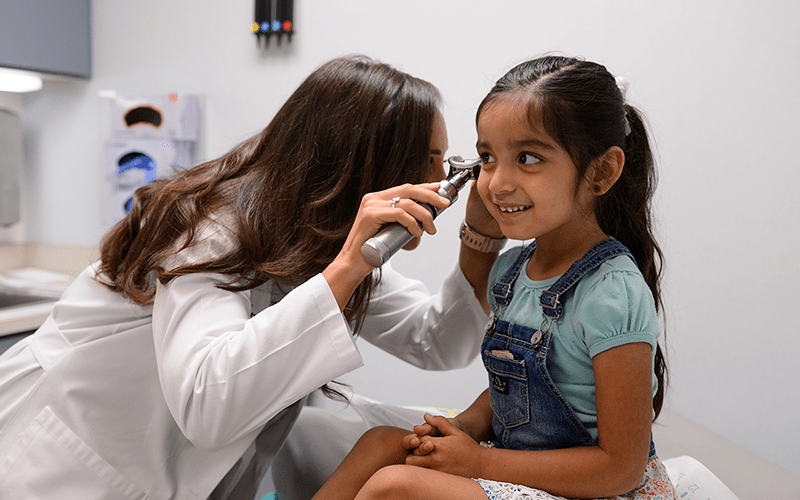 University Health pediatric ENT doctor examining a young girl’s ear.