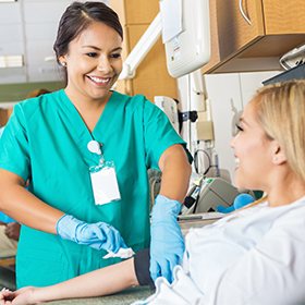 Healthcare preparing to draw blood for a person.